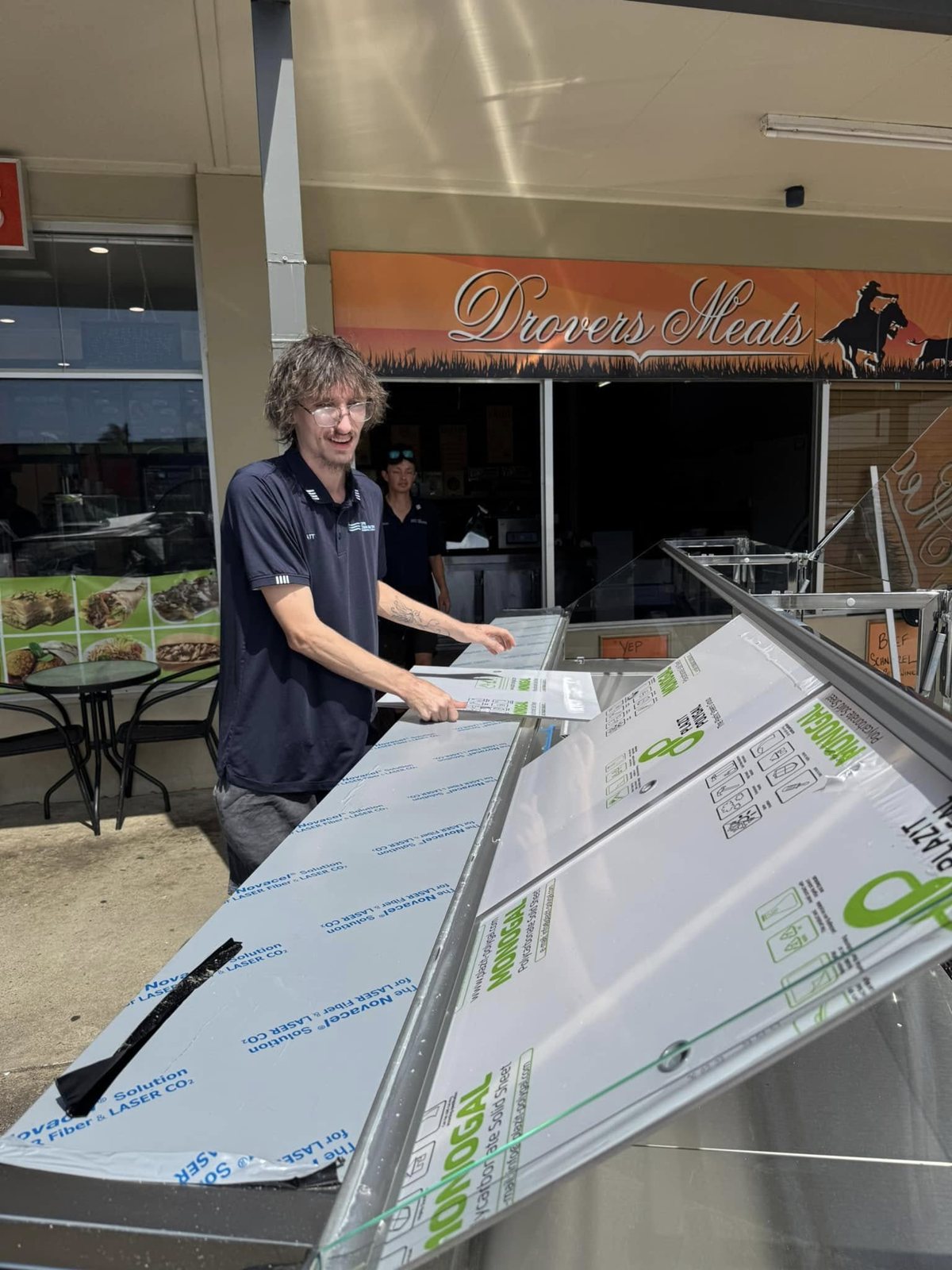 A Coffs Cooling Solutions technician working on a new refrigerated display cabinet outside Drovers Meats